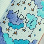 Artistic bullet journal design for April with blue clouds and stars.