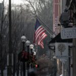 A winter street scene adorned with American flags and festive decorations.